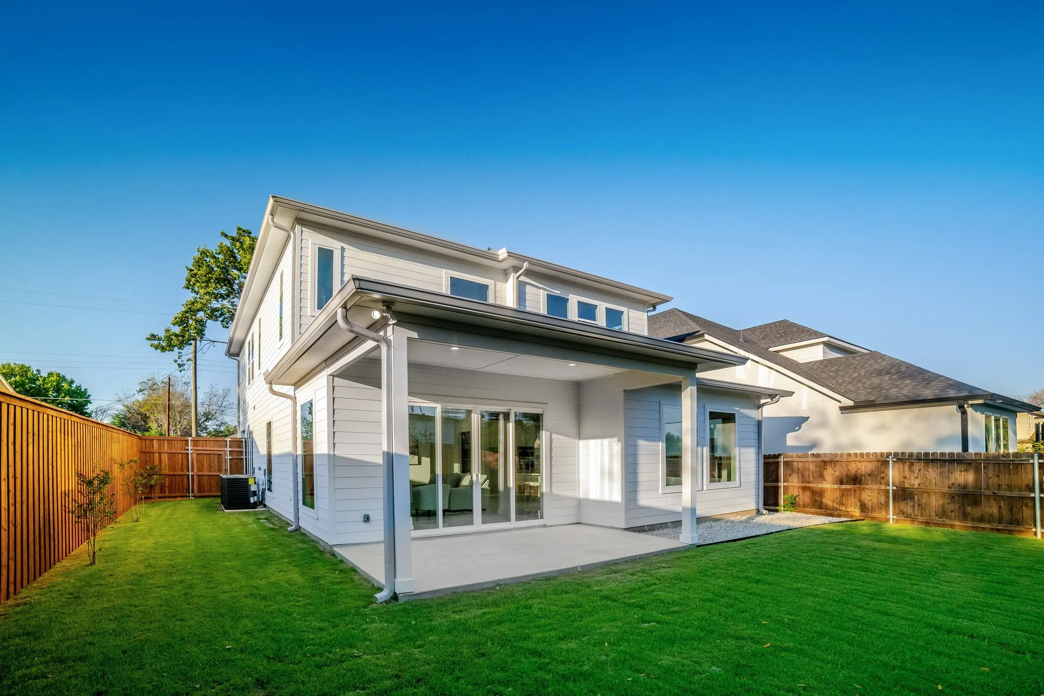 Rear exterior featuring a covered patio, horizontal lap siding, and sliding glass doors
