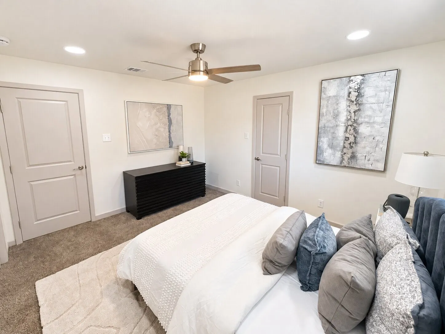 Neutral-toned wall-to-wall carpeting, recessed LED lighting, brushed metal ceiling fan, and multi-panel interior doors