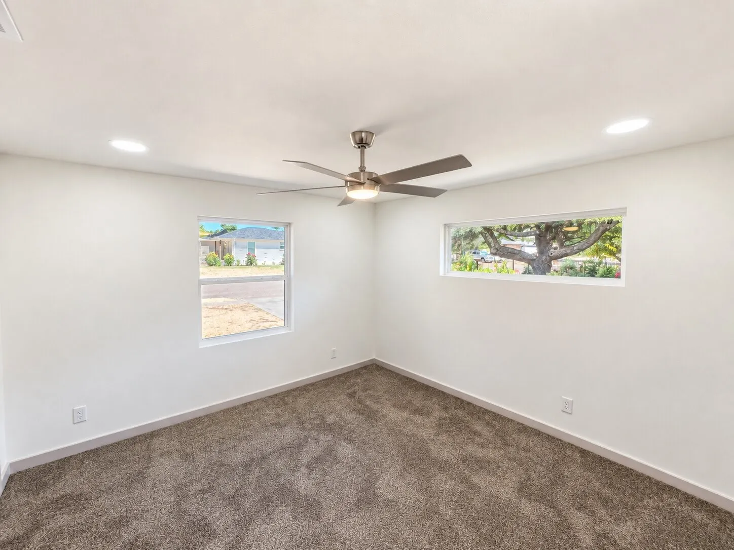 Room featuring neutral wall-to-wall carpeting, recessed ceiling lighting, a brushed-nickel finish ceiling fan, and dual window configurations