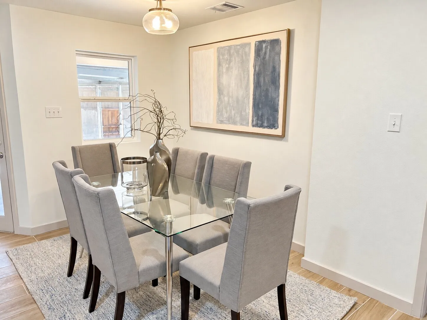 Dining space featuring neutral wall paint, wood-finish flooring, and a glass-shade pendant light