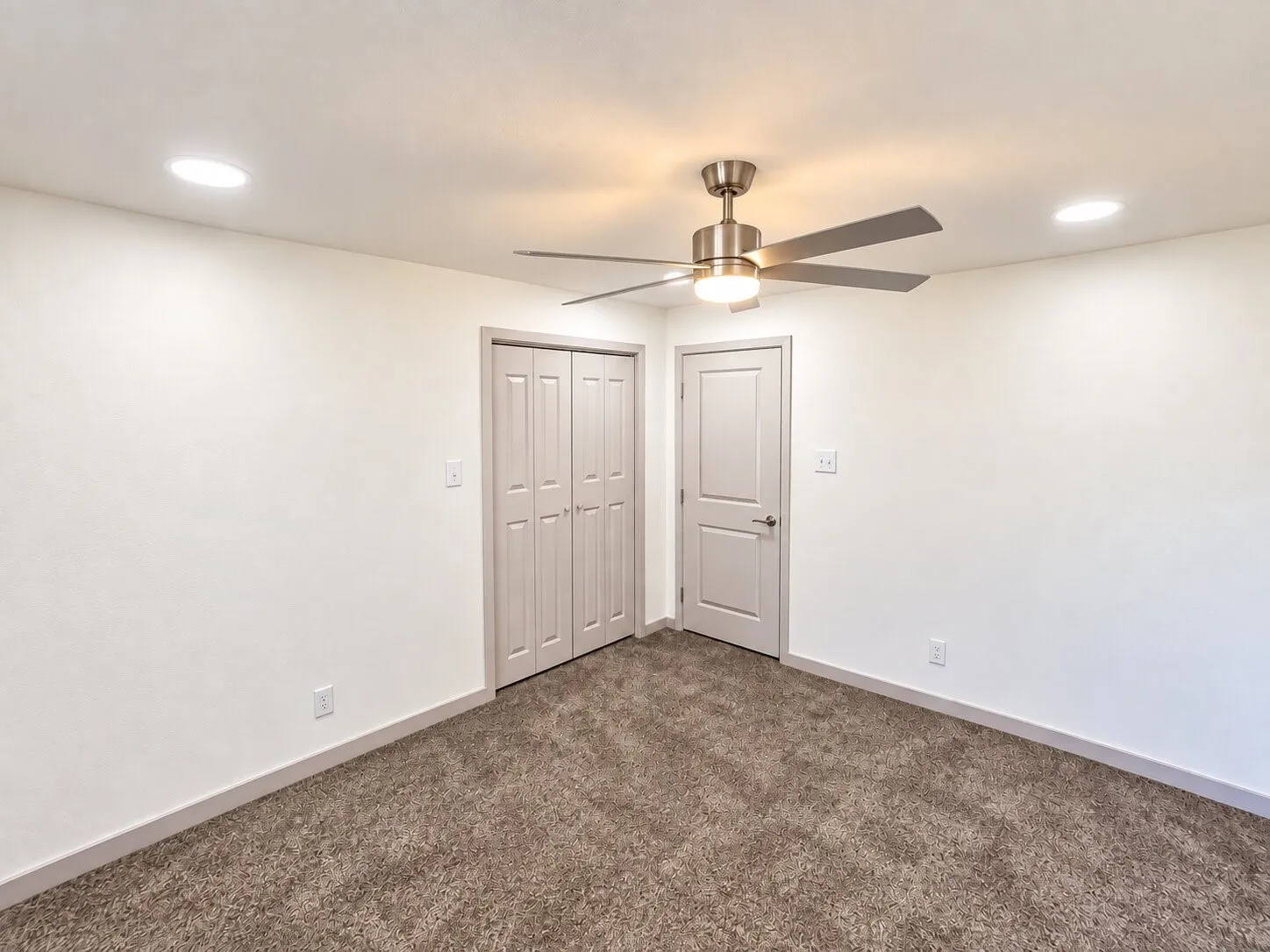 Interior space featuring neutral wall-to-wall carpeting, recessed ceiling lighting, and a multi-blade metal ceiling fan