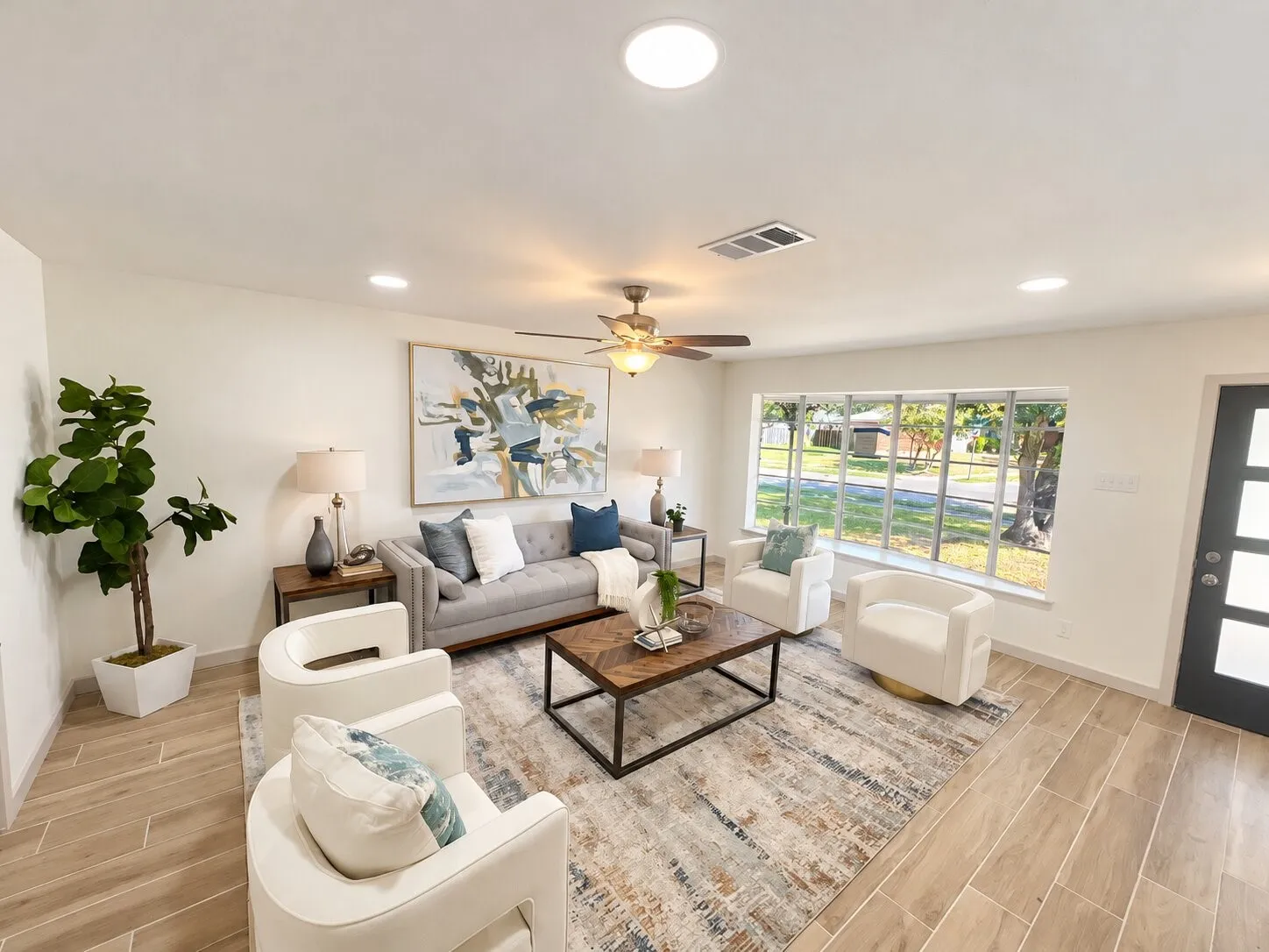 Living area featuring wood-finish tile flooring, recessed lighting, a ceiling fan with integrated light fixture, a large picture window, and a modern glass-paneled entry door