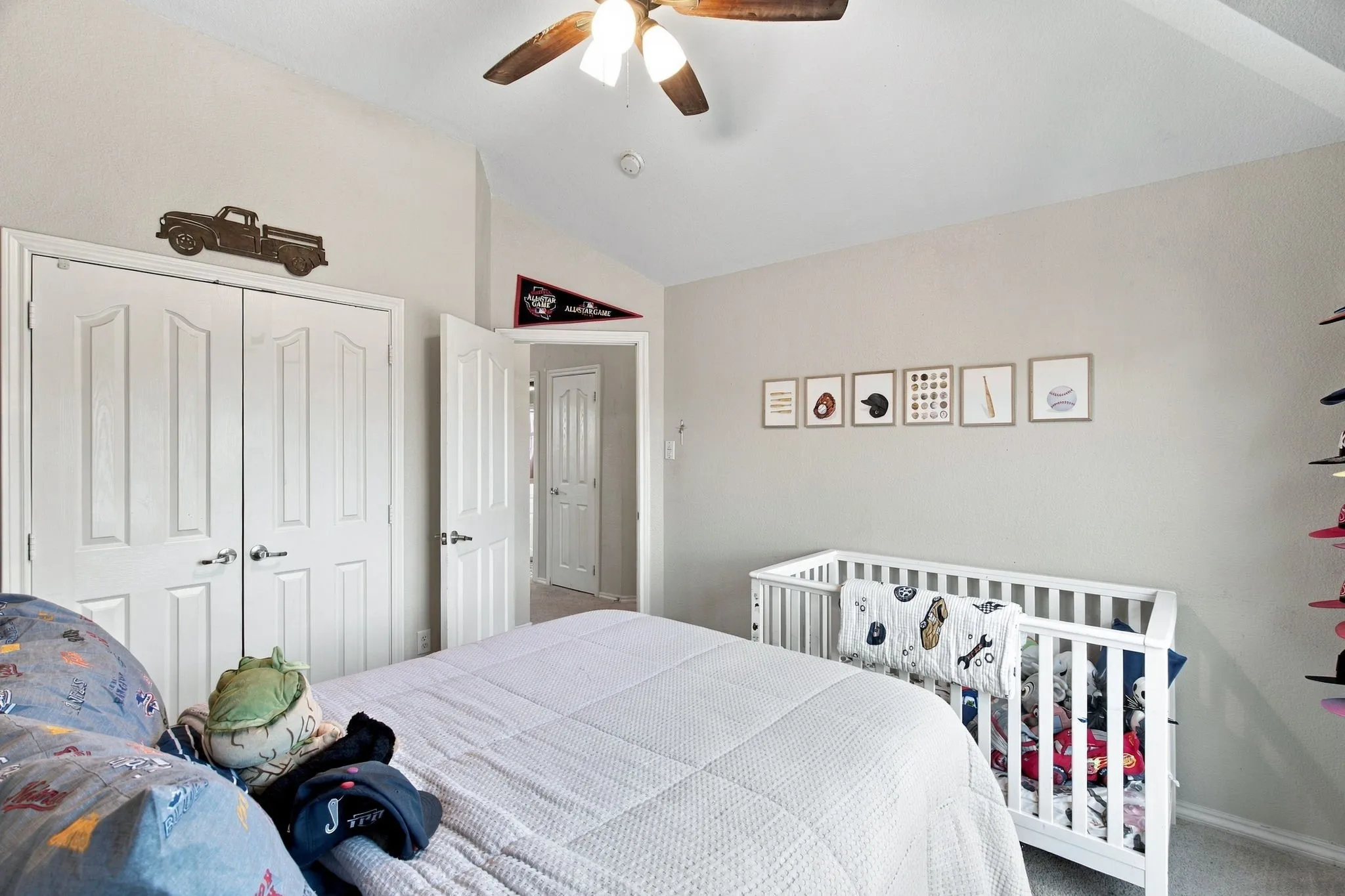 Vaulted ceiling featuring a central ceiling fan with integrated lighting, paired with double-panel closet doors
