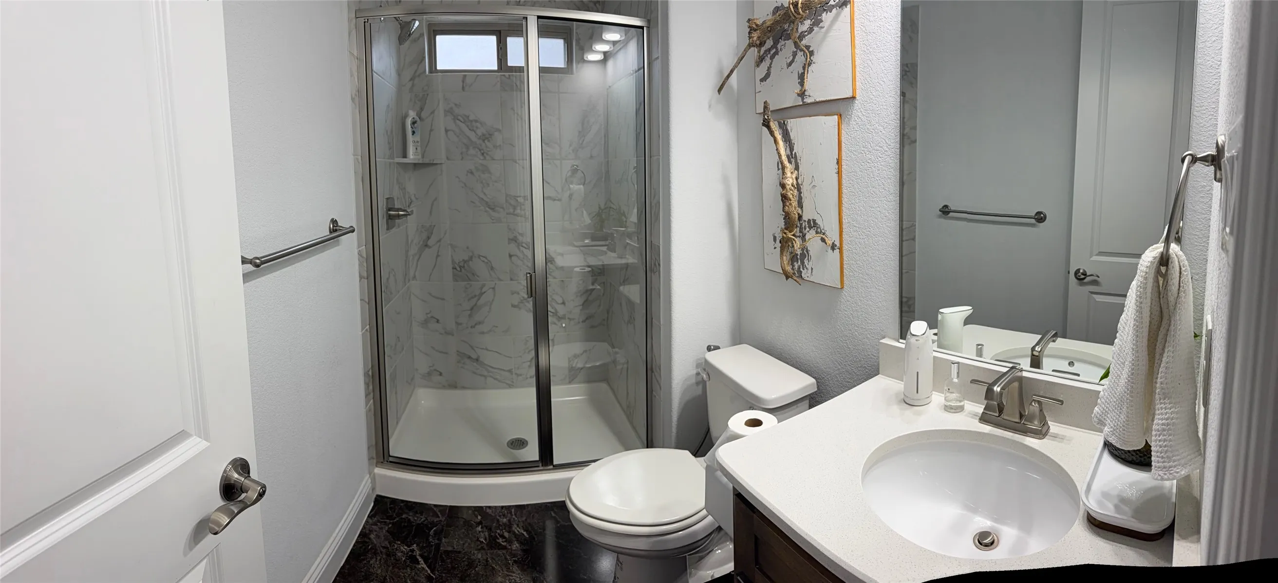 Bathroom featuring a walk-in shower with glass enclosure and surround tiling, vanity with a light-toned countertop, and integrated sink