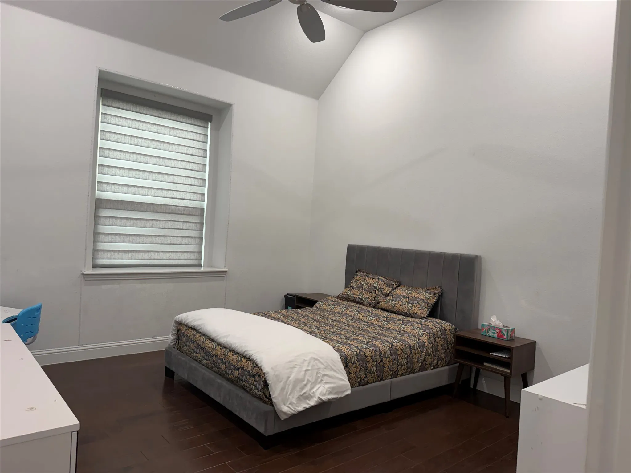 Open-concept living space featuring wood-finish flooring, tray ceilings, recessed lighting, and a tiered crystal chandelier