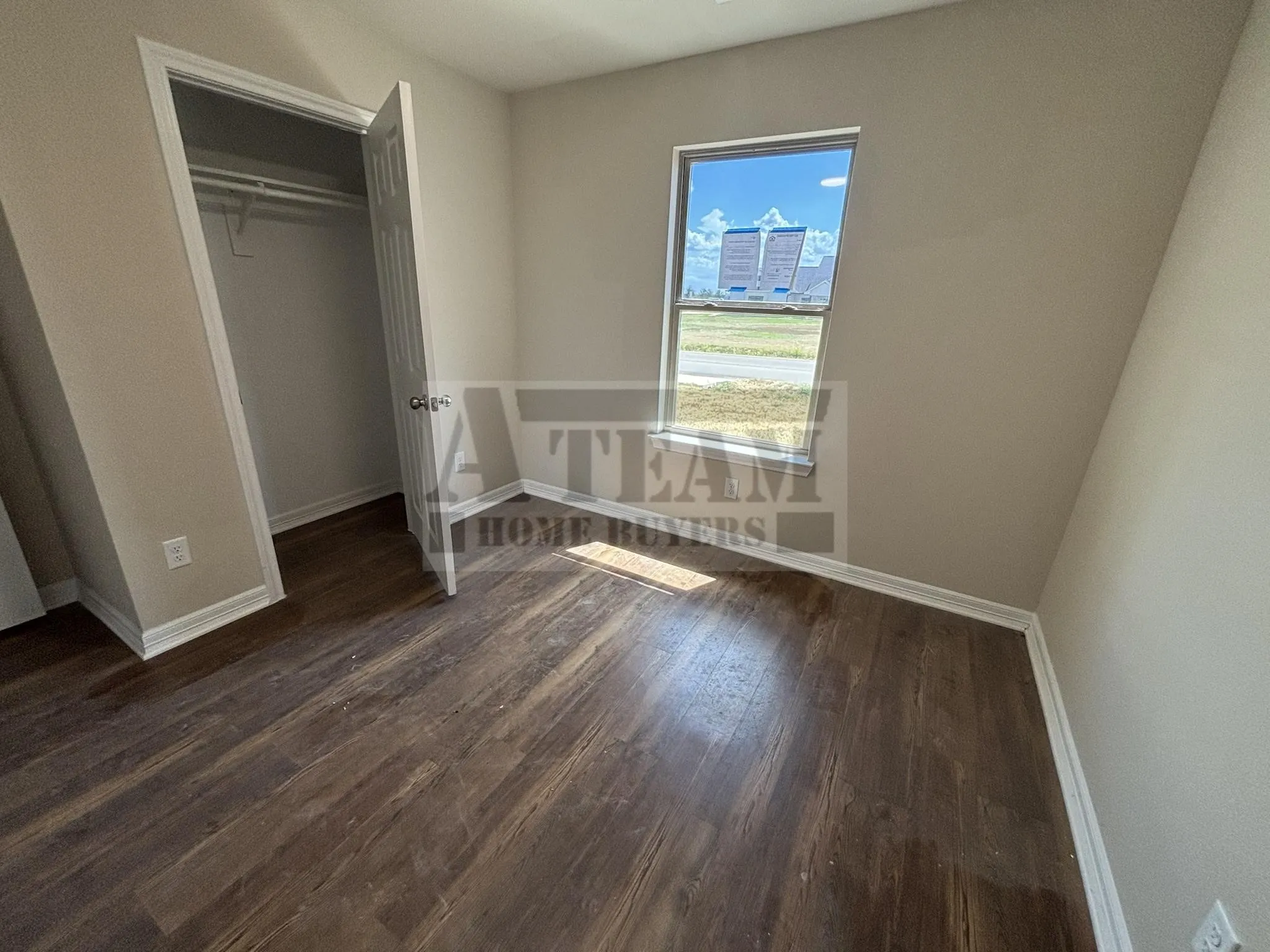 Interior room featuring wood-finish flooring, neutral wall paint, and a single-panel window