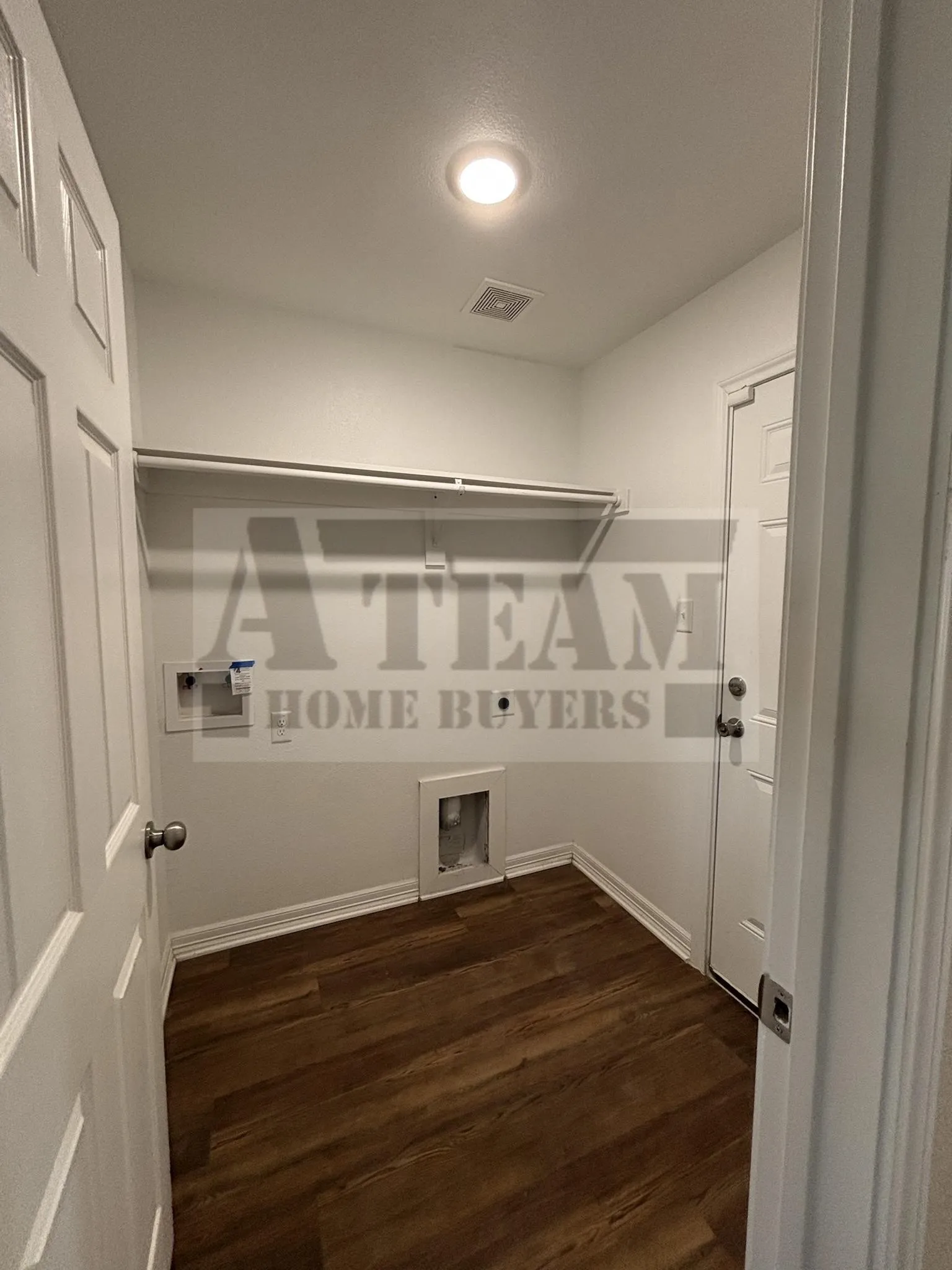 Utility room featuring wood-finish flooring, recessed ceiling lighting, and built-in overhead shelving