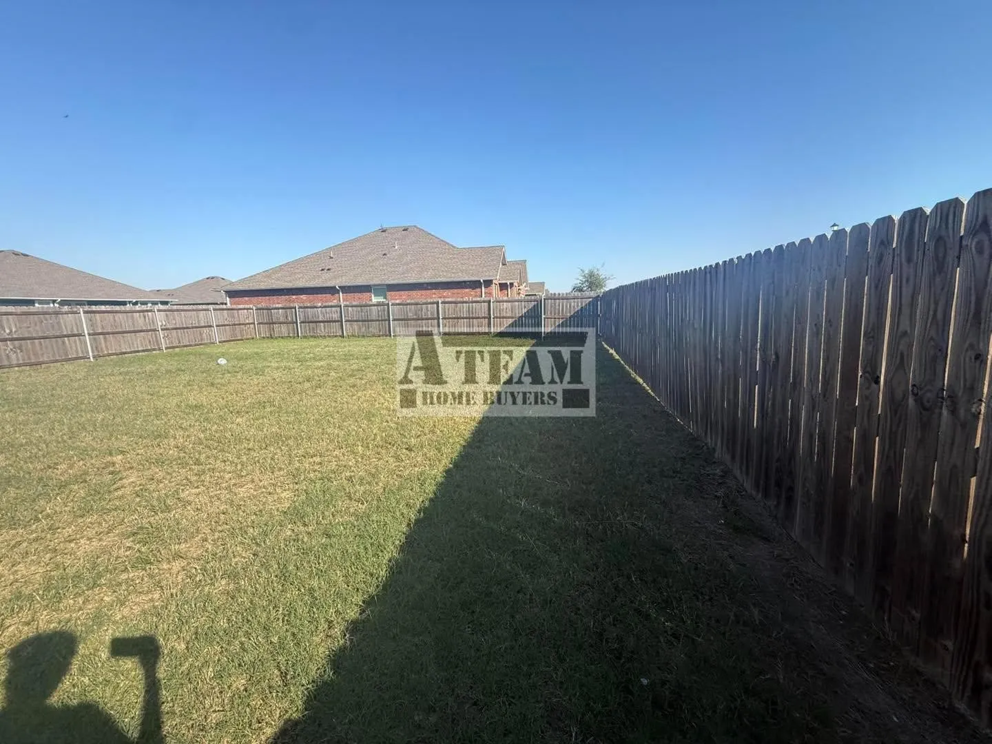 Backyard featuring a grass lawn and a full-perimeter wood privacy fence