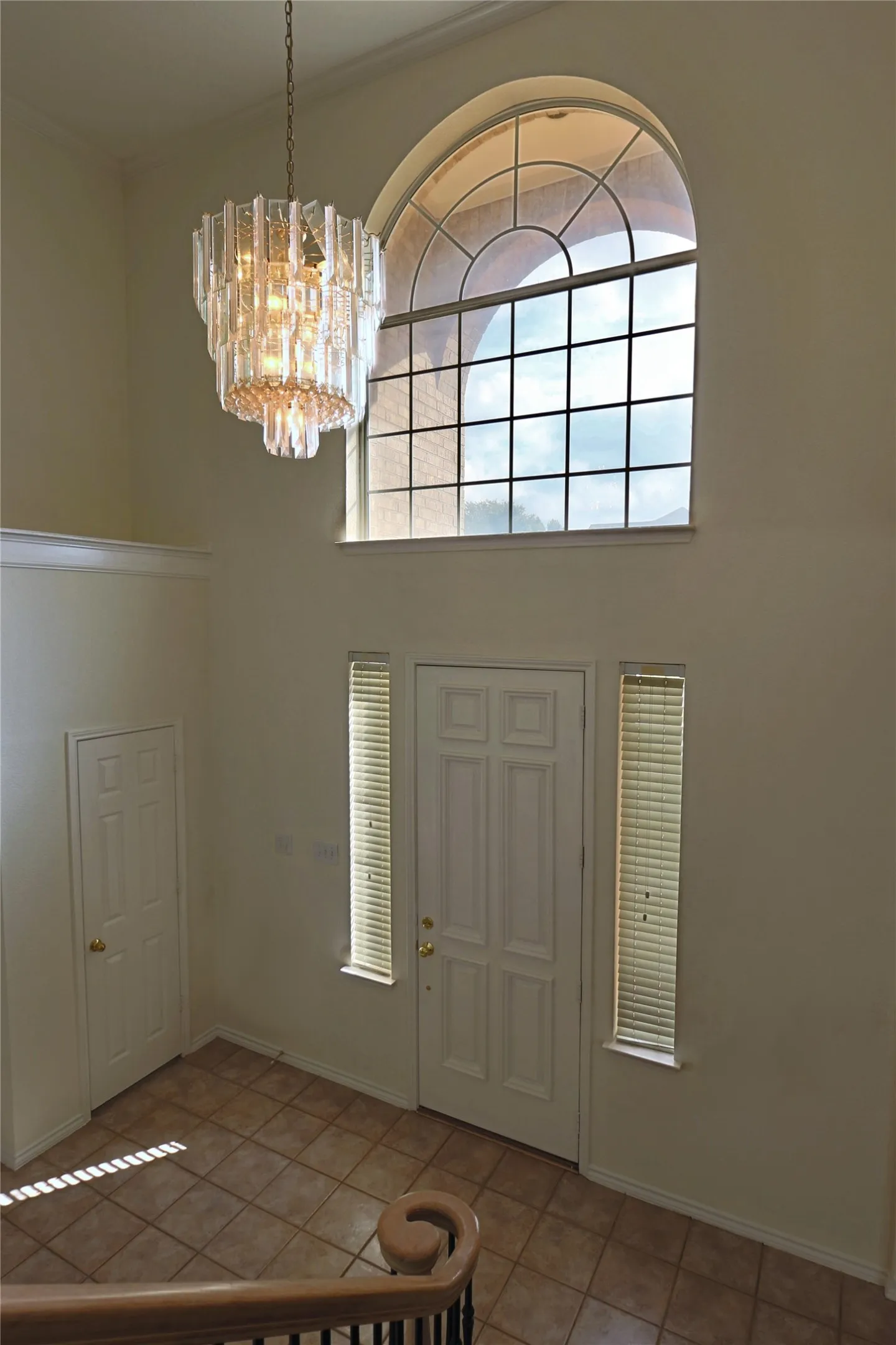 Bright entry with high ceiling and crystal chandelier.