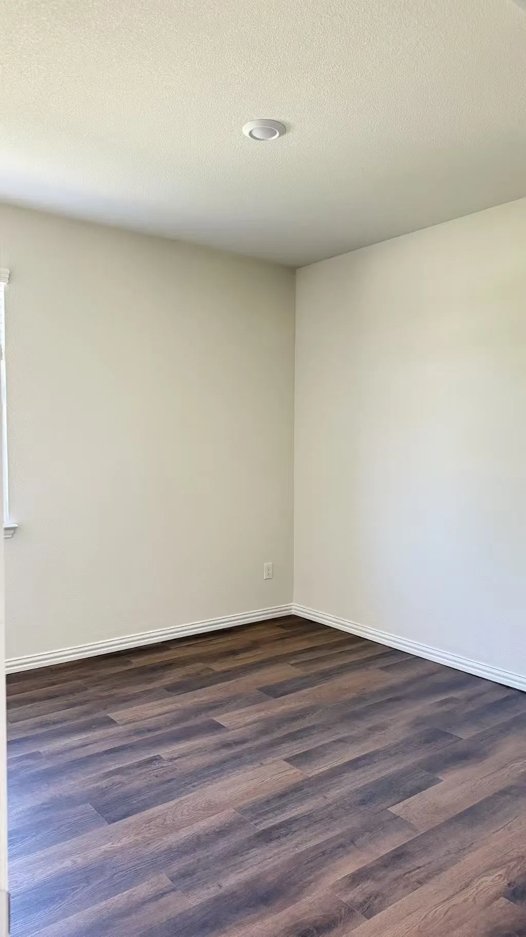 Neutral wall paint, recessed ceiling lighting, and wood-finish flooring