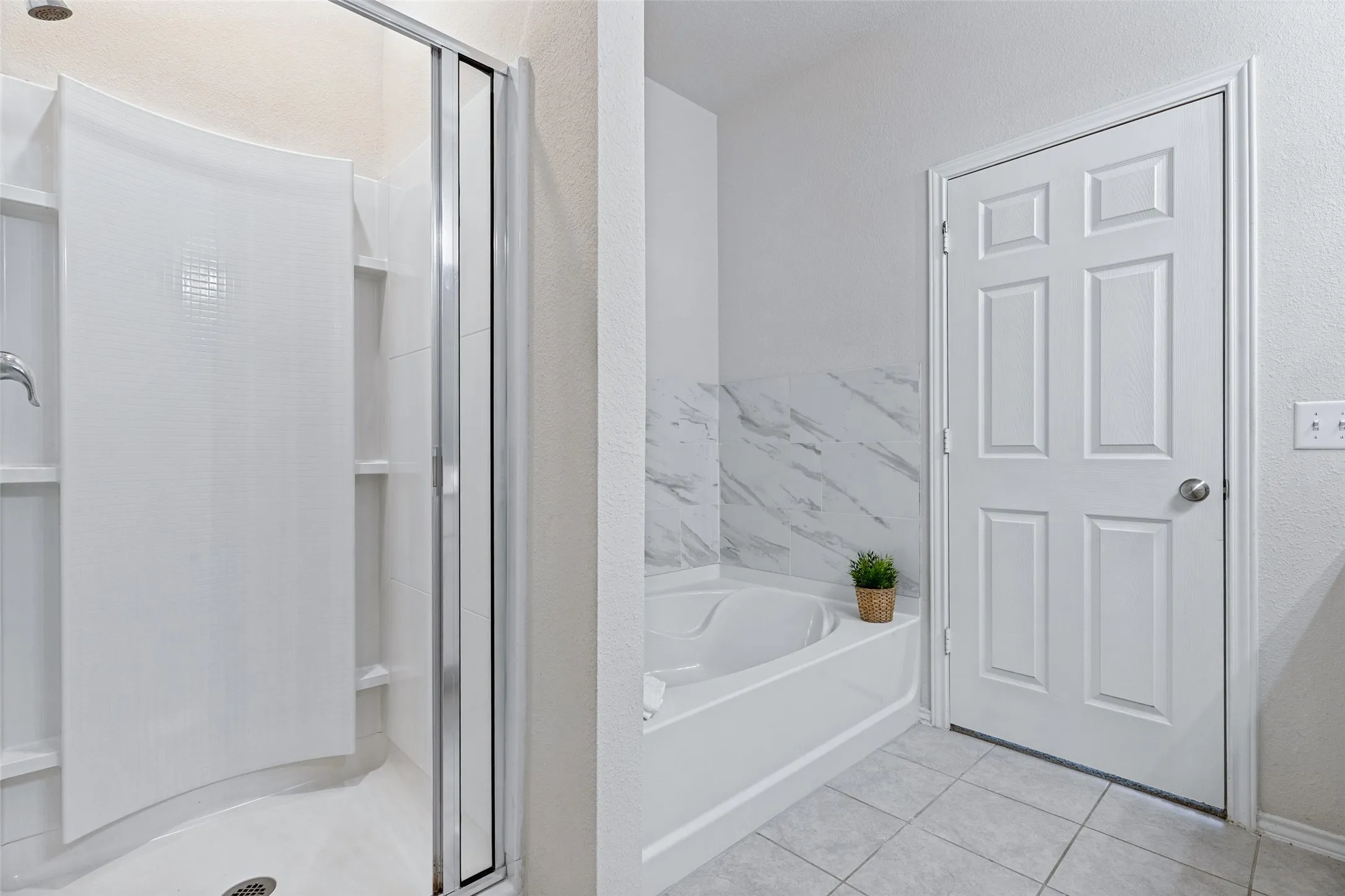 Another view of master bathroom with walk-in shower and separate soaking tub with decorative tile surround