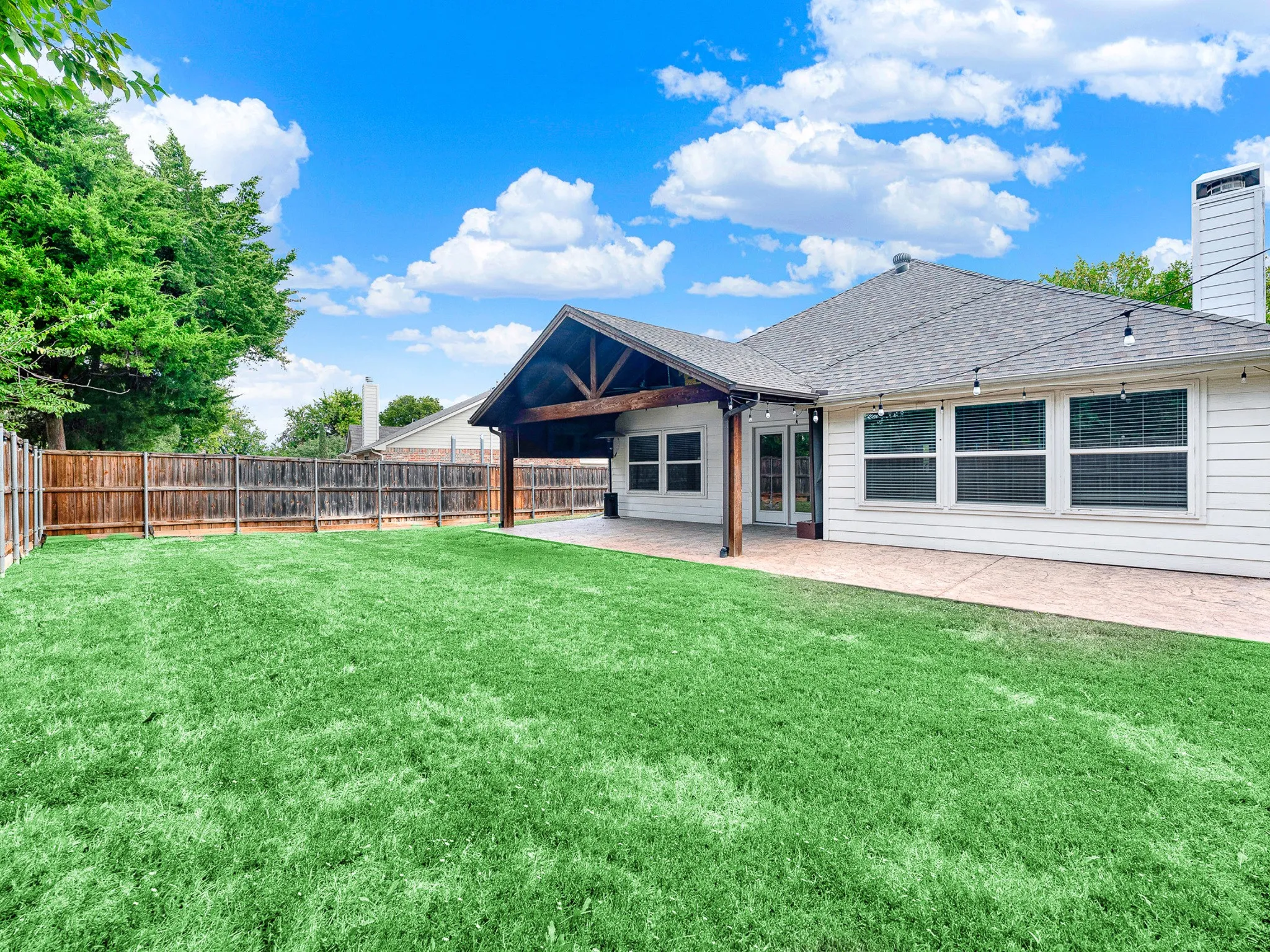 Extended patio for grilling and entertaining in a large, private backyard