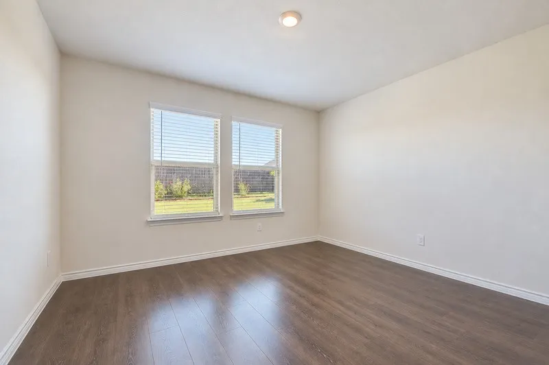 Wood-finish flooring, recessed ceiling light, dual windows with blinds, and white wall finishes