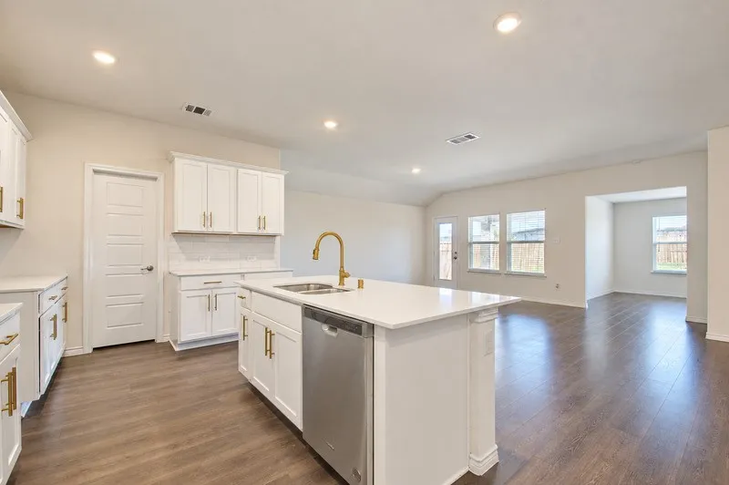Kitchen island with an undermount sink, brass finish faucet, and an integrated dishwasher