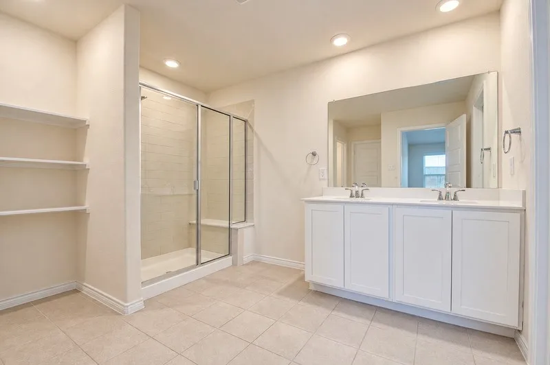 Dual vanity with undermount sinks, frameless mirror, and white shaker-style cabinetry