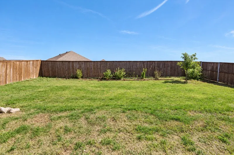 Expansive green lawn with mature wood fencing