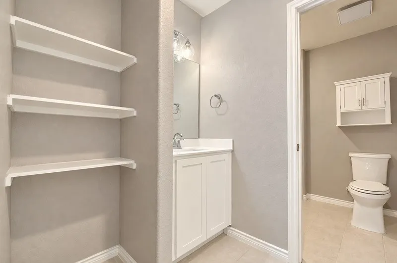 Vanity with single-basin sink, wall-mounted mirror, and overhead light fixture