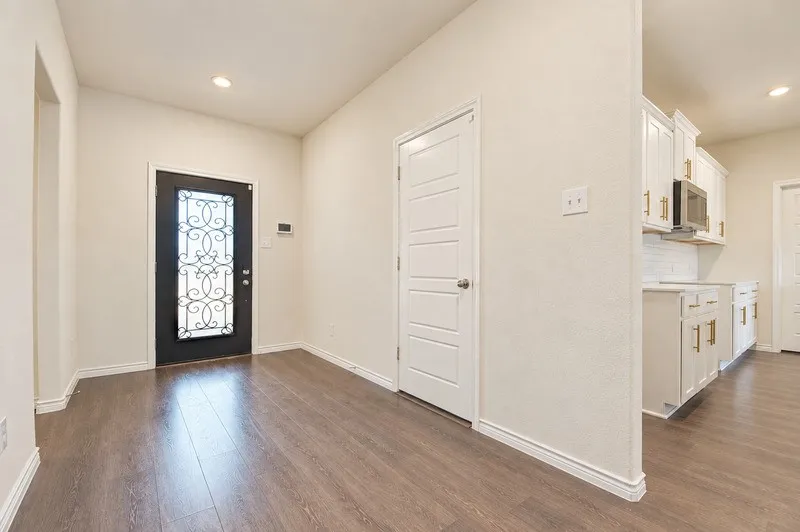 Wood-finish flooring, recessed lighting, and a decorative glass-paneled entry door