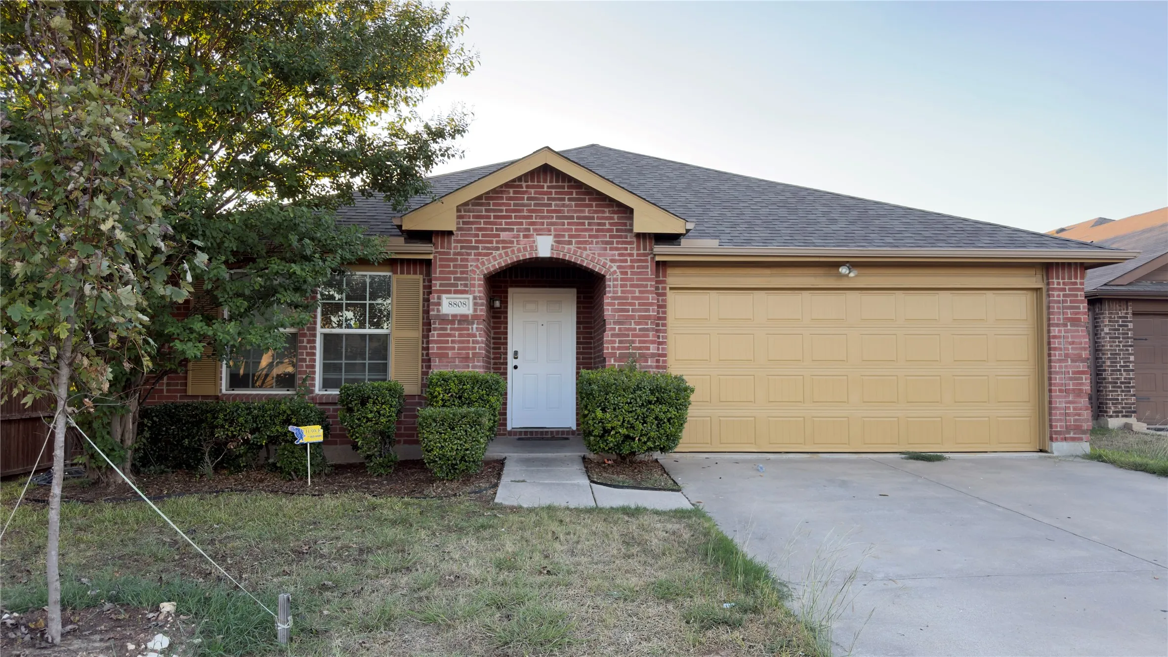 Brick exterior featuring a gabled roofline, covered entryway, and an attached two-car garage