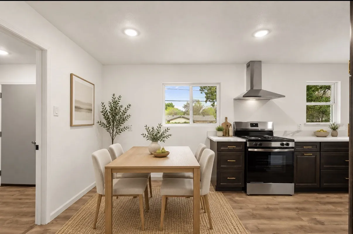 Kitchen featuring dark cabinetry, solid-surface countertops, stainless steel range, stainless steel vent hood, and wood-finish flooring