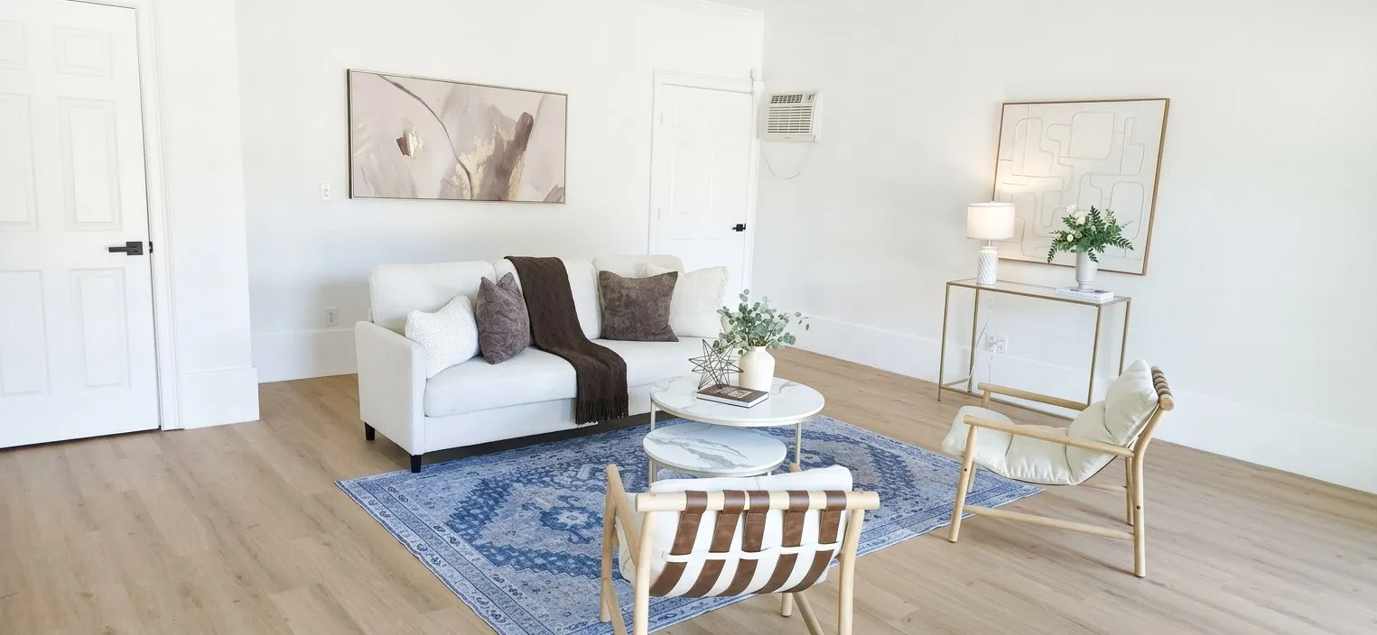 Living area featuring wood-finish flooring, white walls, and a wall-mounted cooling unit