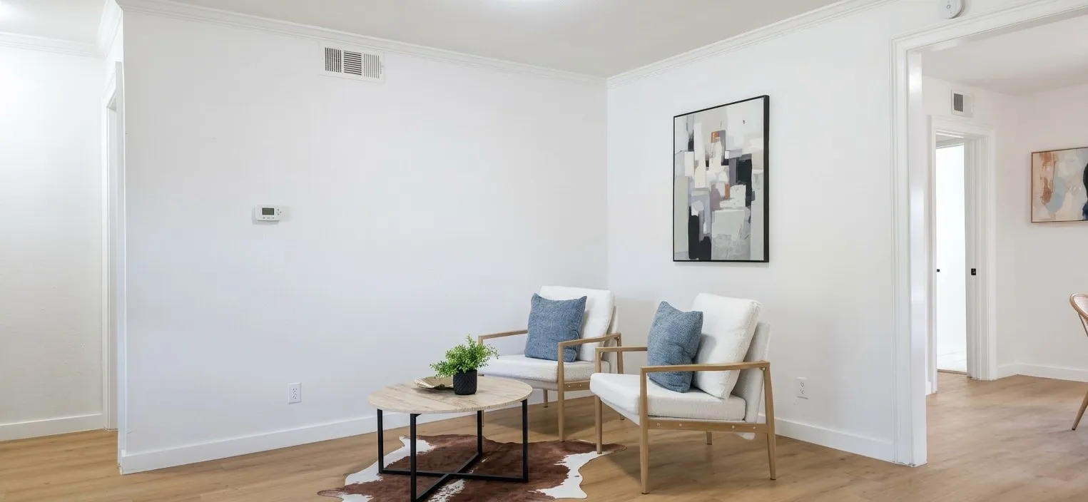 Neutral interior space featuring wood-finish flooring and crown molding