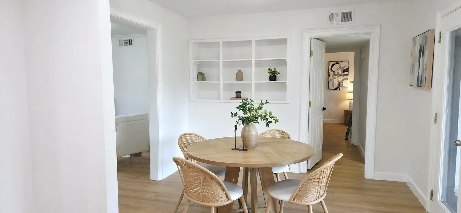 Built-in white recessed shelving, wood-finish flooring, and crisp white wall finish