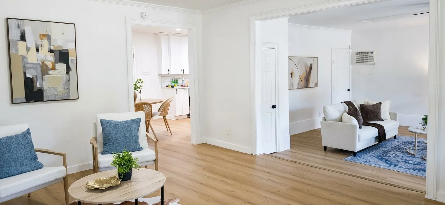 Neutral interior with wood-finish flooring, white cabinetry, and multi-panel interior doors