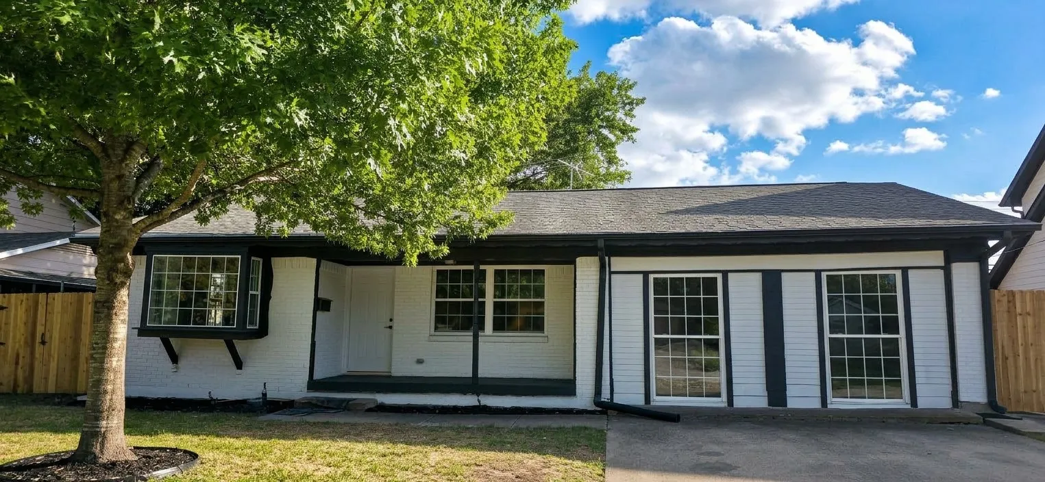 Single-story residence featuring white painted brick exterior, dark trim accents, a front-facing bay window, and a covered entryway
