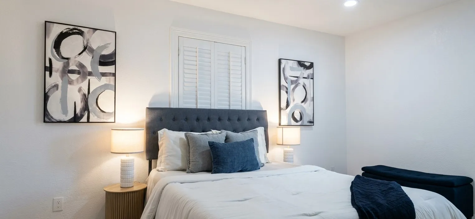 Bedroom featuring white walls, recessed ceiling lighting, and plantation shutters