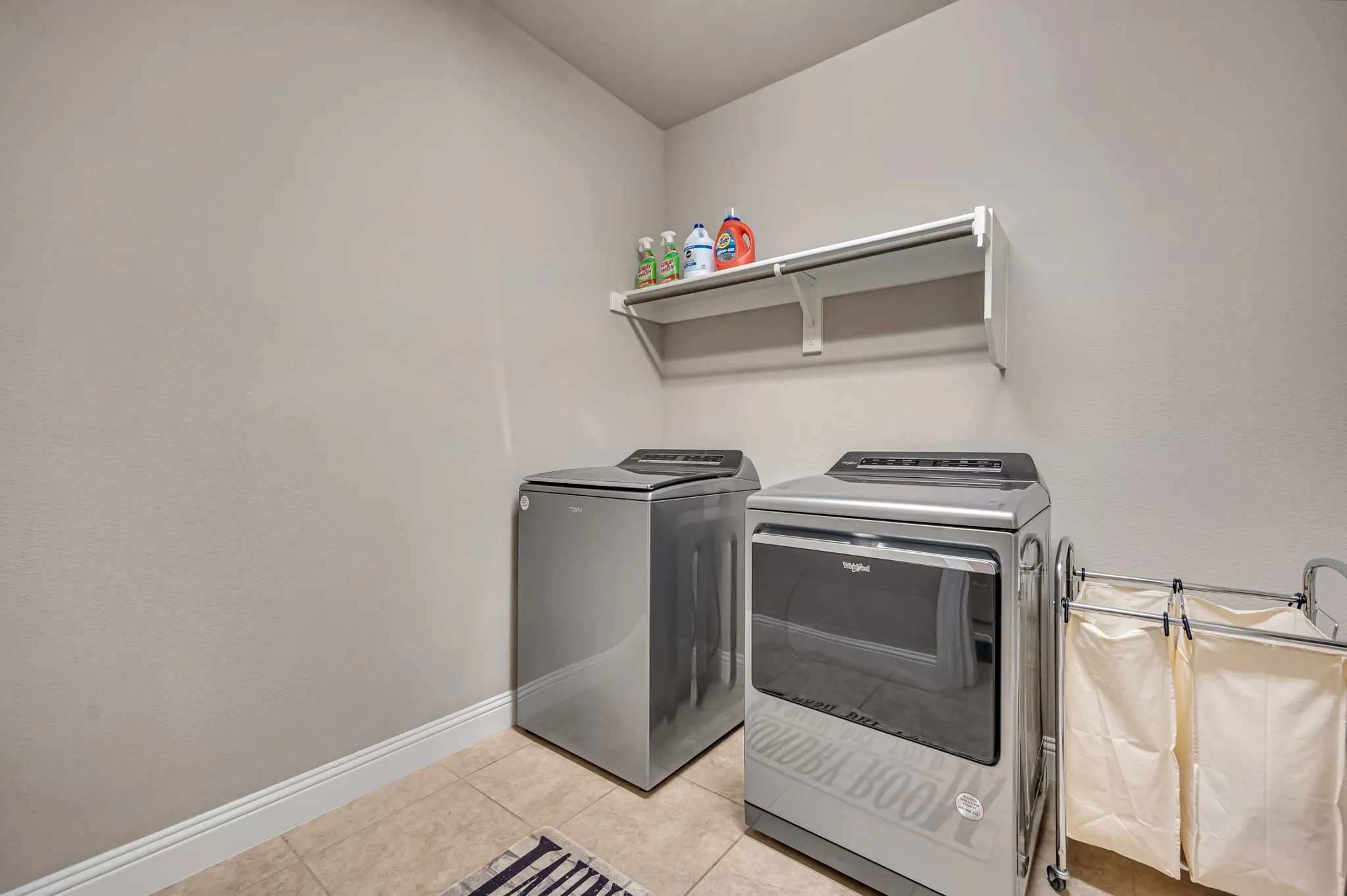 Laundry space featuring tile flooring and built-in wall shelving