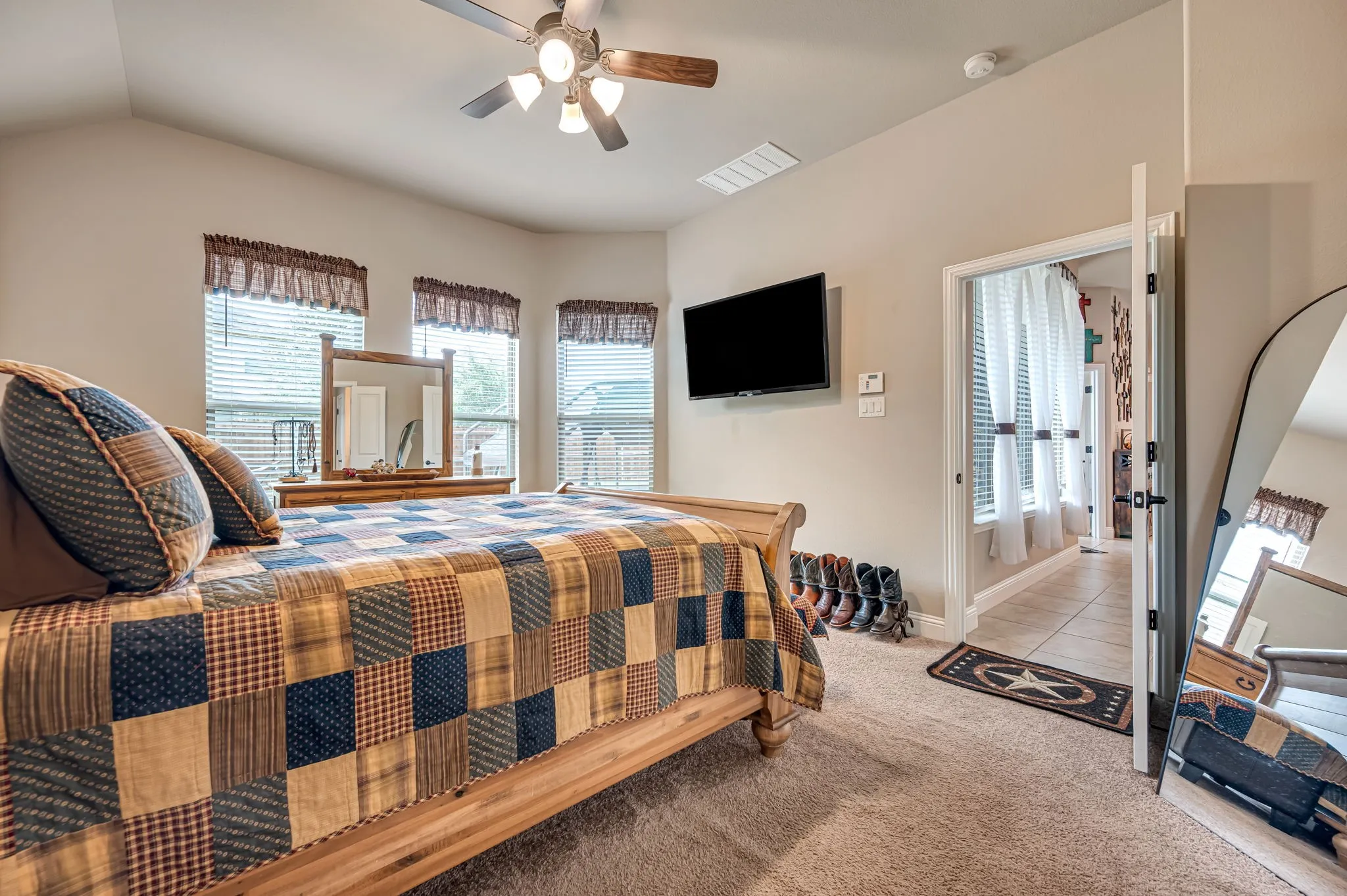 Vaulted ceilings, three-paneled bay window, and a multi-light ceiling fan with integrated light fixture