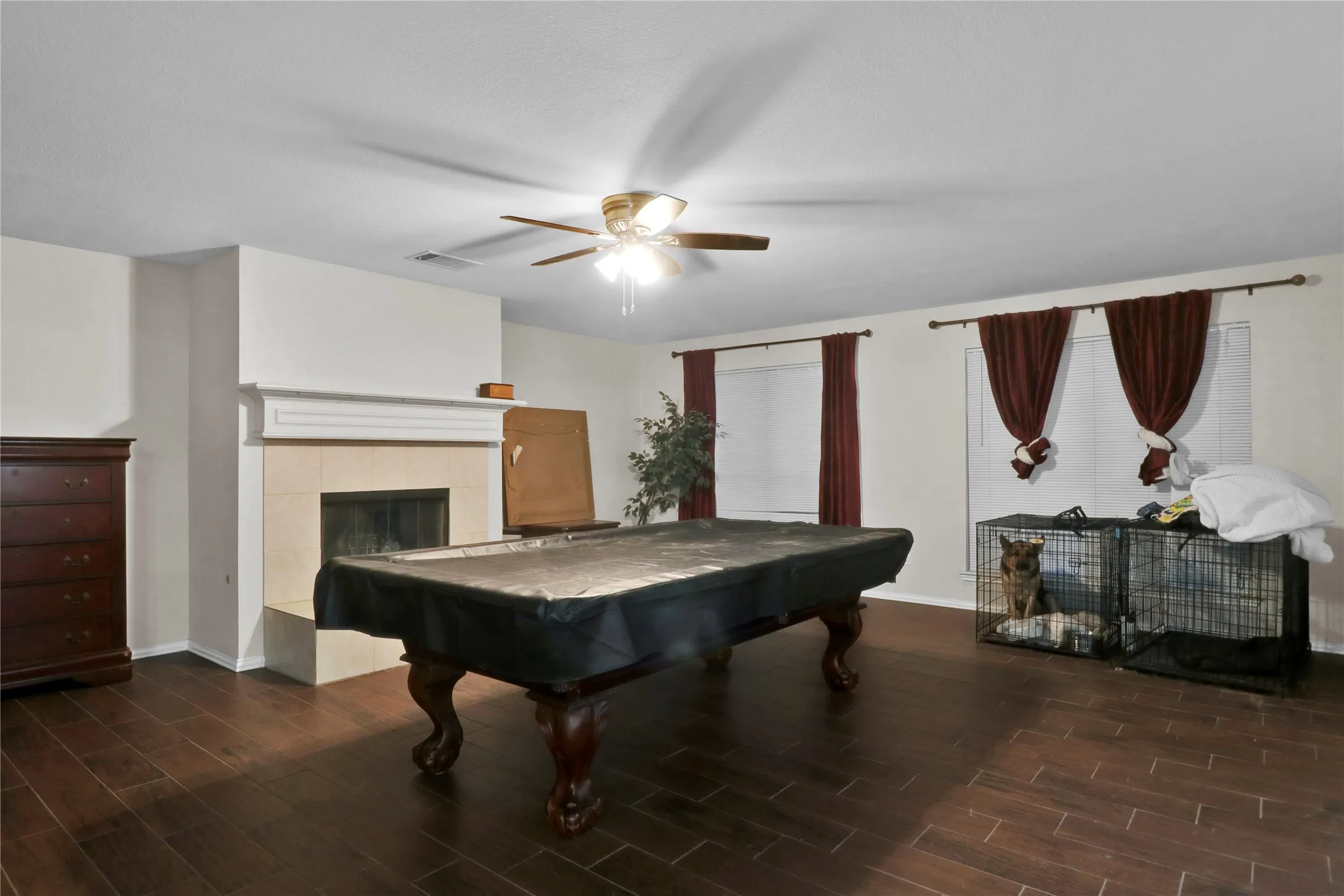 Downstairs den with fireplace and ceiling fan. Owner has their pool table set up there as perfect entertaining area off kitchen and leading to back yard.