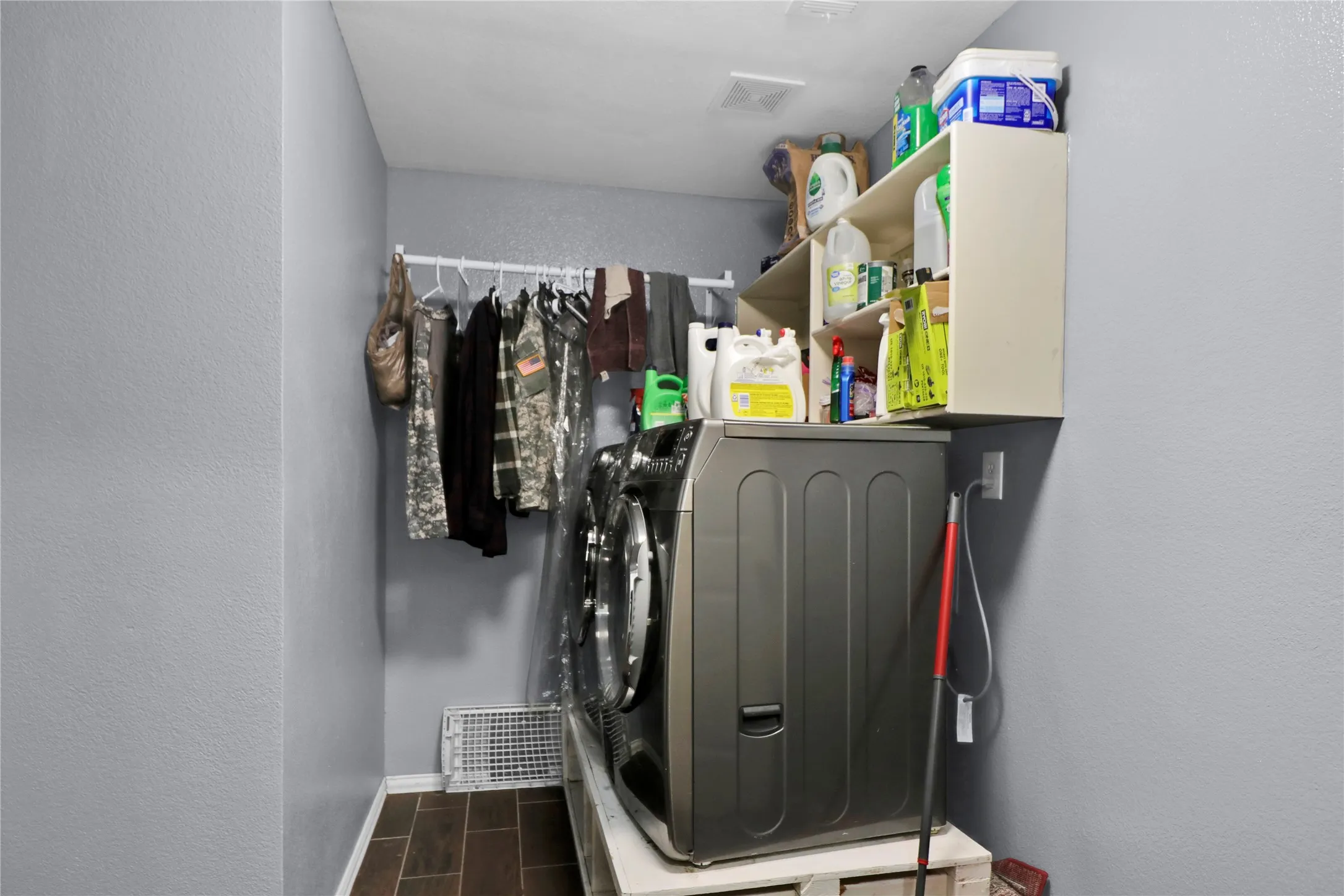 Laundry room with drying rack and shelves.