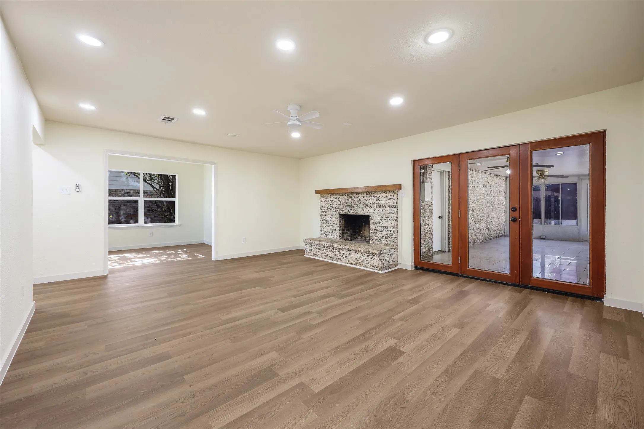 Spacious room with wood-finish flooring, recessed lighting, and a ceiling fan
