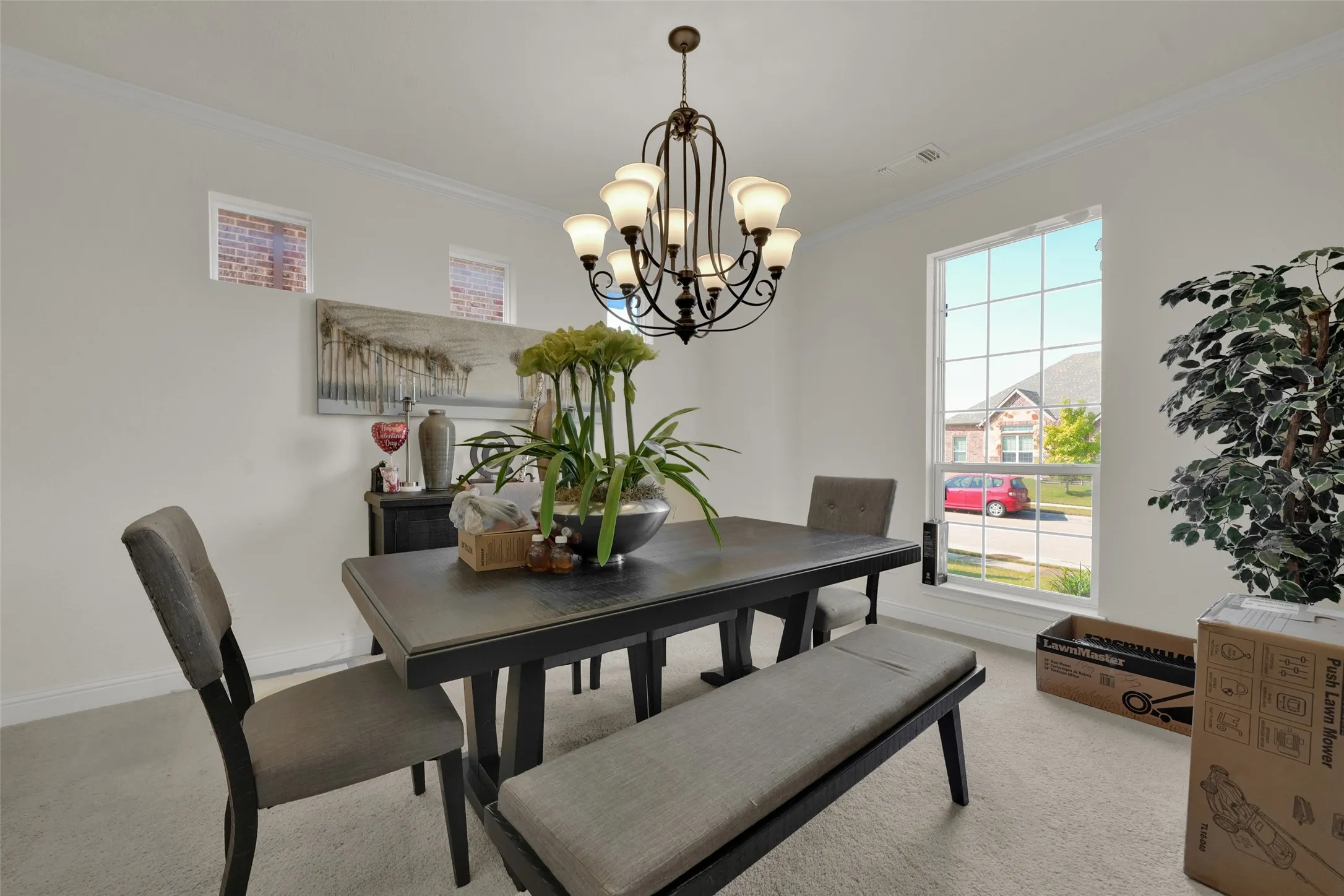 Multi-light metal chandelier, crown molding, and large window with grid panes