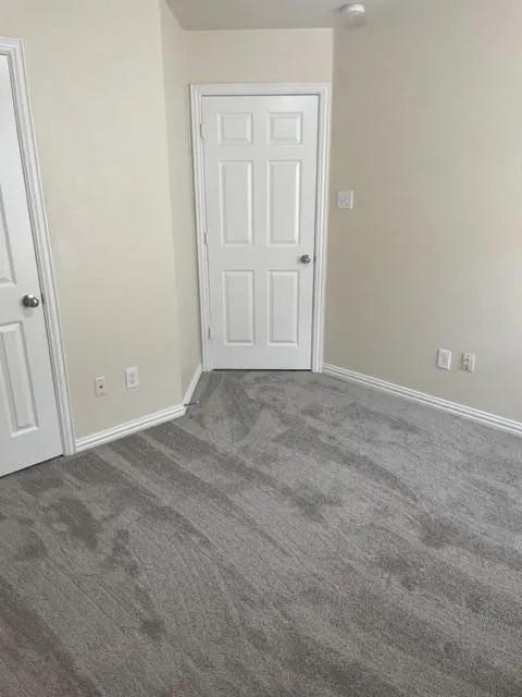 Neutral wall palette featuring six-panel interior doors, plush wall-to-wall carpeting, and integrated electrical outlets