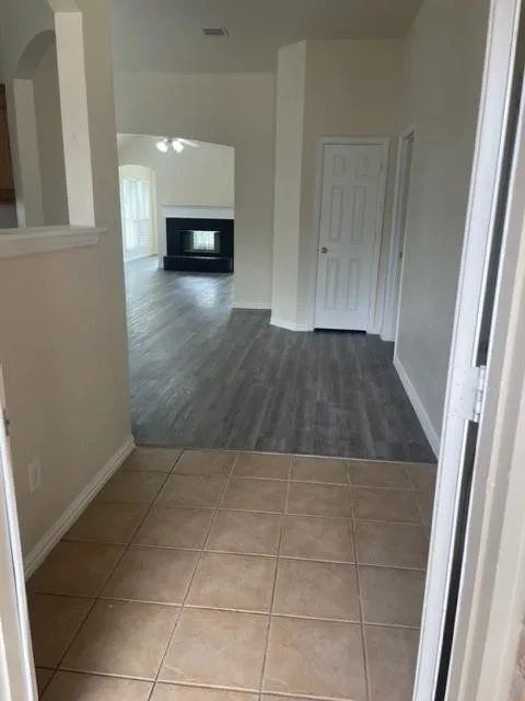 Entryway featuring tile flooring, wood-finish flooring, and a fireplace with a black surround