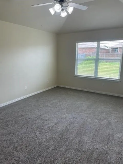 Vaulted ceiling featuring a central multi-light fan fixture, neutral wall finishes, and wall-to-wall carpeting