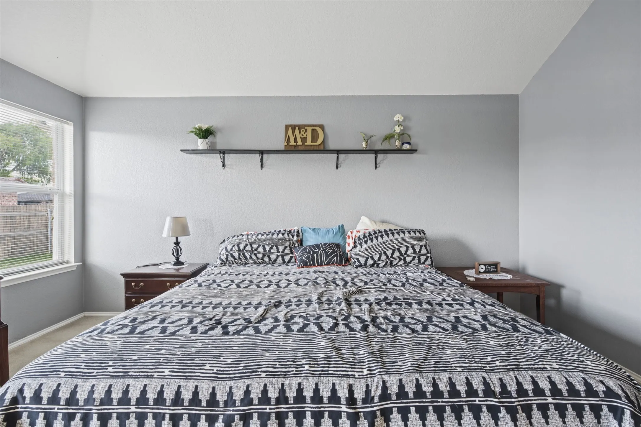 Vaulted ceiling, neutral wall tones, and mounted shelving unit