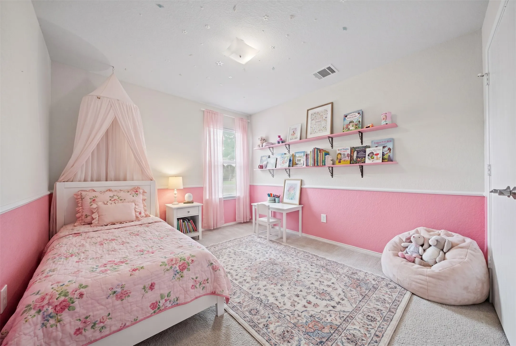 Room featuring two-tone wall paint with a chair rail, wall-mounted shelving, and a central ceiling light fixture