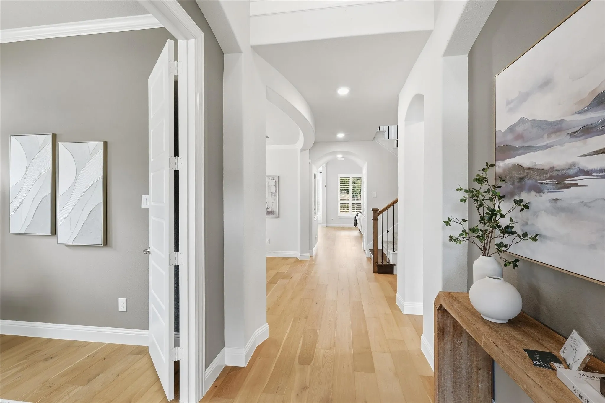 Elongated foyer that flows into the home office with French doors.