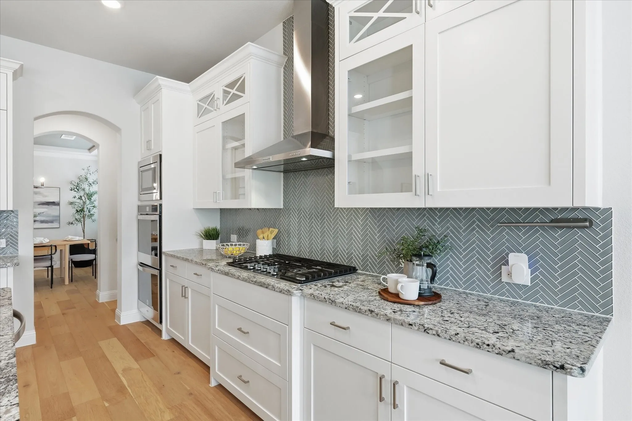 Crisp white ceiling-height cabinets, double ovens, a gas stove, and a walk-in pantry make this bright kitchen and breakfast nook the ultimate space to cook and entertain!