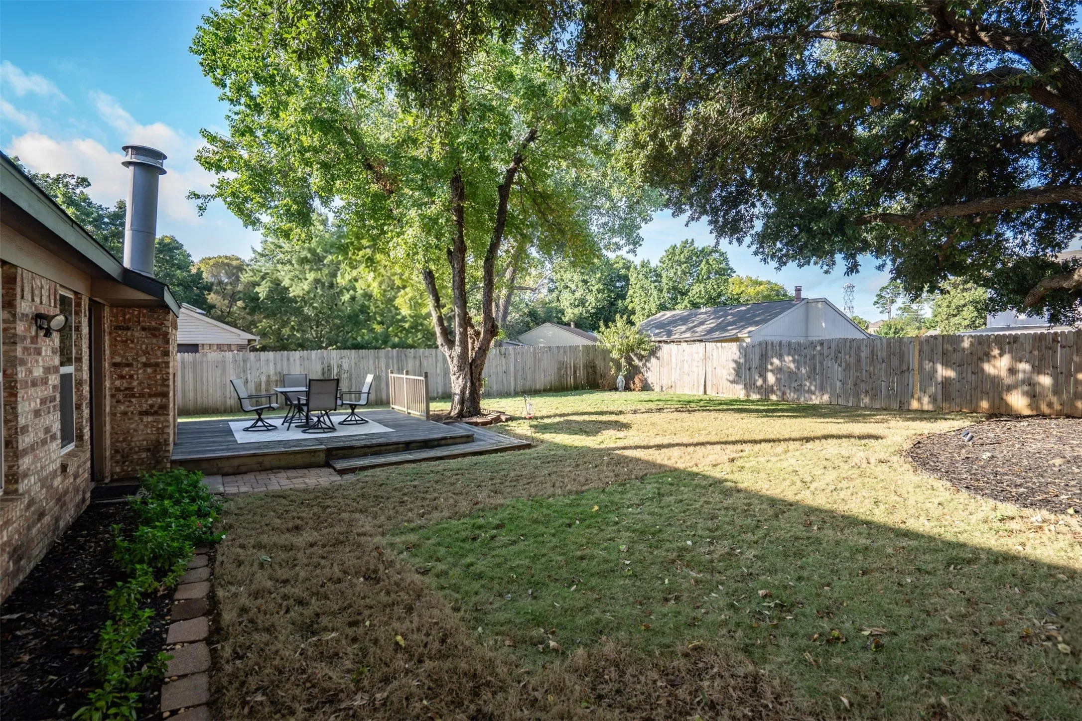 Big fenced backyard with a sprinkler system.