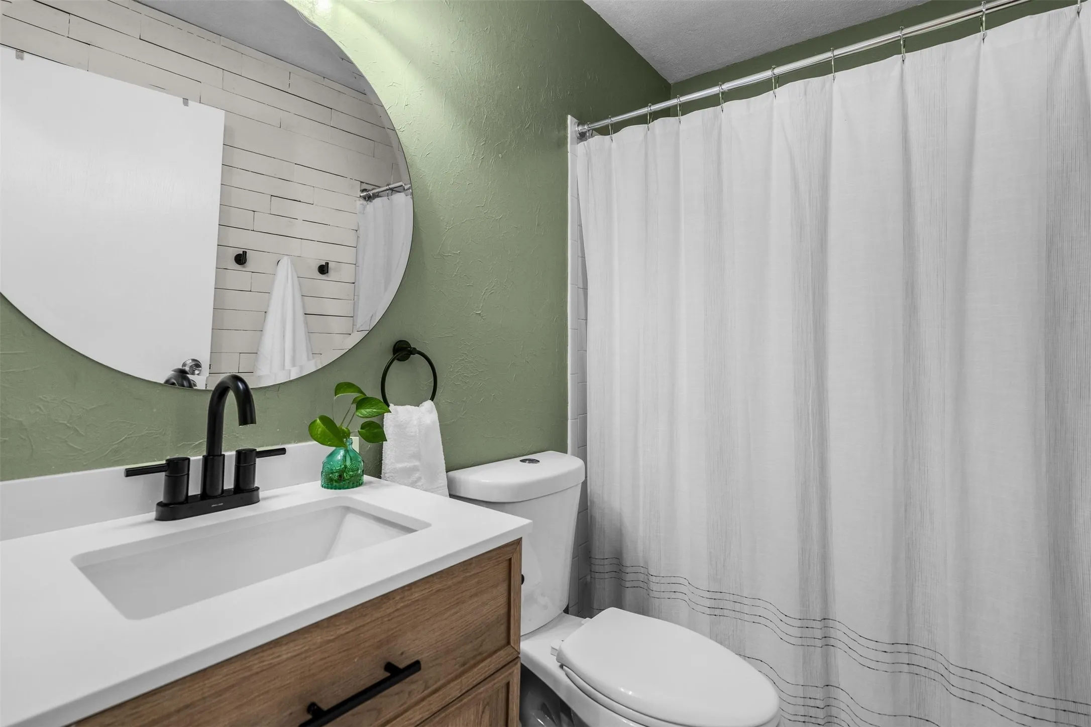 Refreshed hall bath with subway tile and a white vanity.