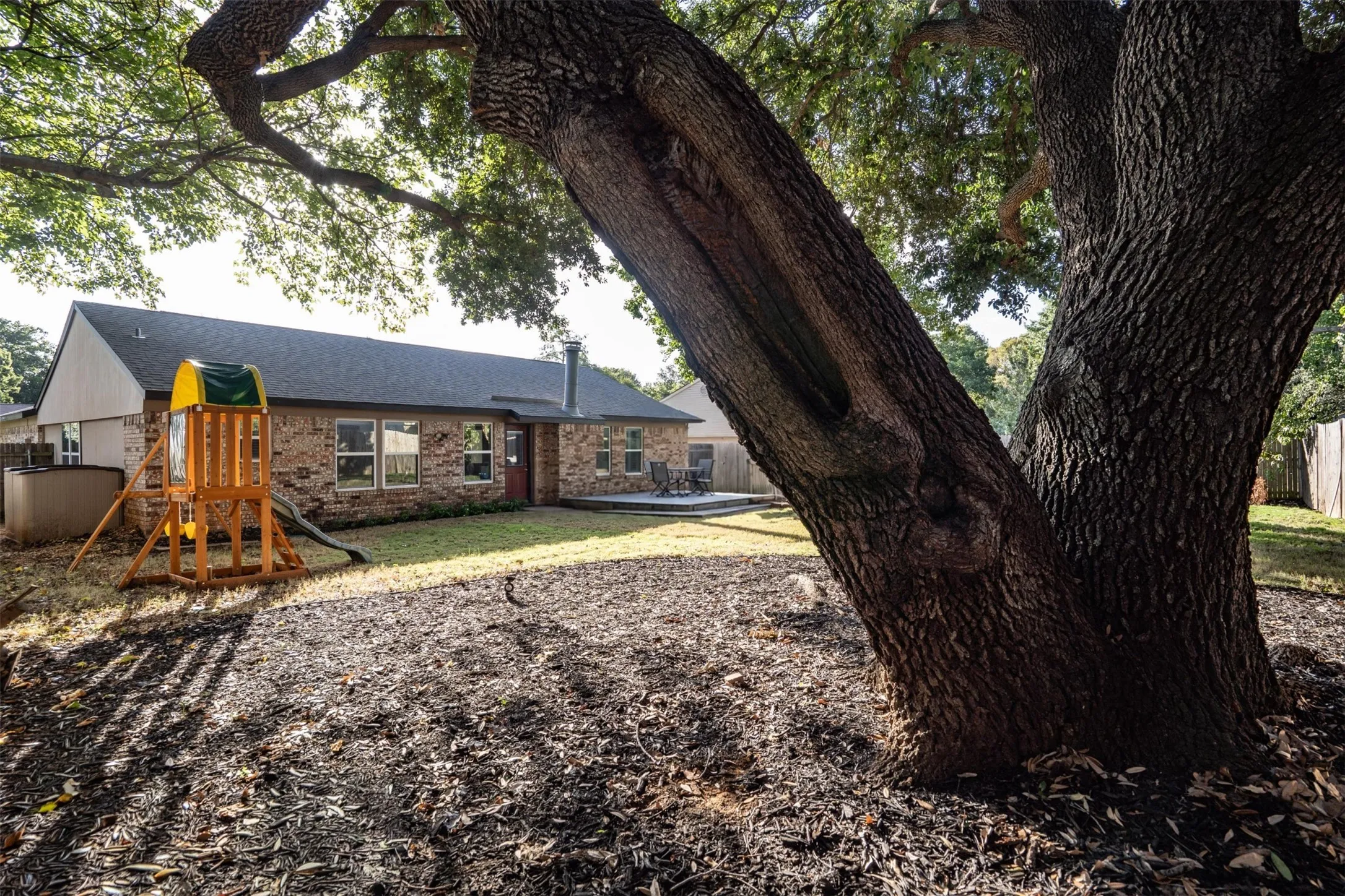 A towering oak anchors the backyard.