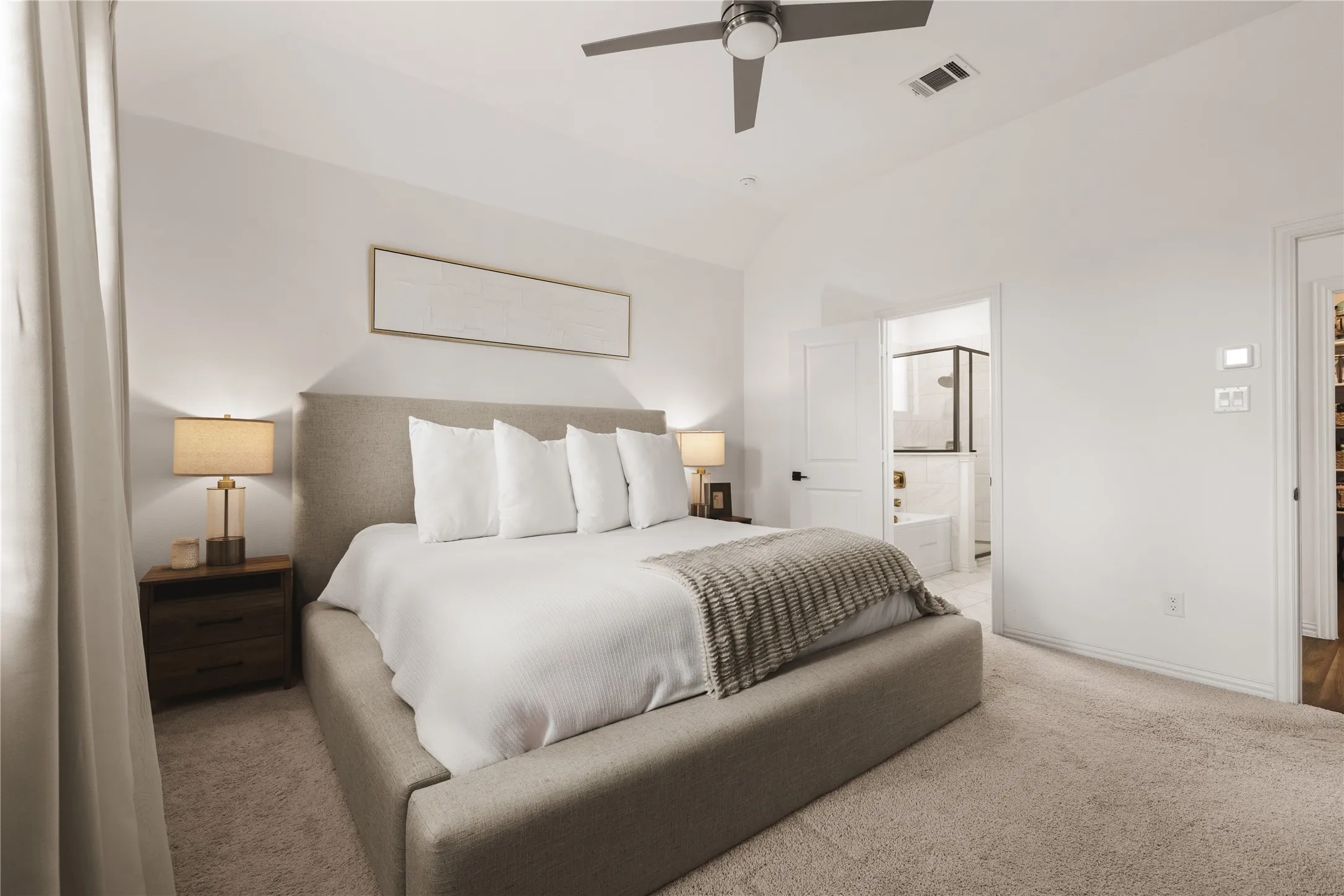 Vaulted ceiling, ceiling fan, neutral wall-to-wall carpeting, and solid-core interior doors
