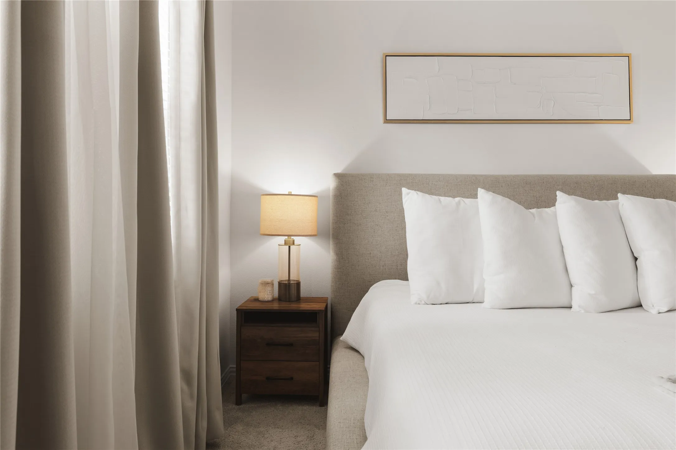 Neutral-toned wall-to-wall carpeting and floor-to-ceiling drapery