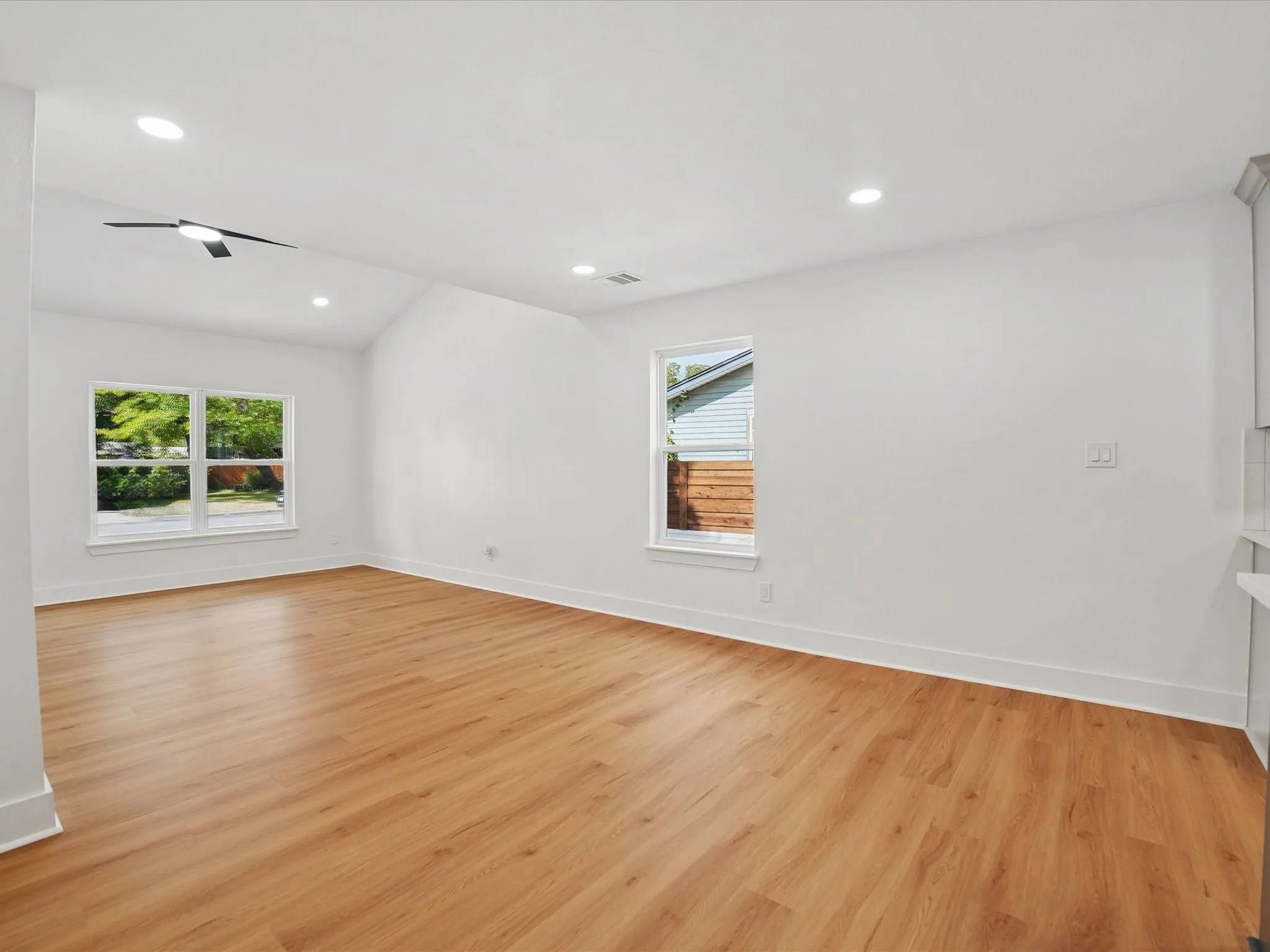 Vaulted ceilings with recessed lighting, wood-finish flooring, and double-pane windows