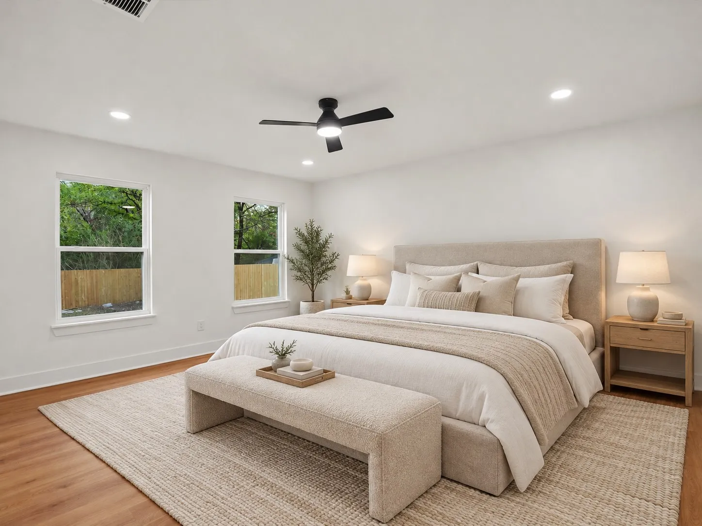 Spacious room featuring wood-finish flooring, recessed lighting, a matte black ceiling fan, and dual pane windows